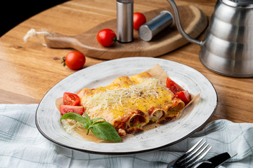 Cannelloni stuffed with turkey and vegetables, with melted cheddar and mozzarella cheese