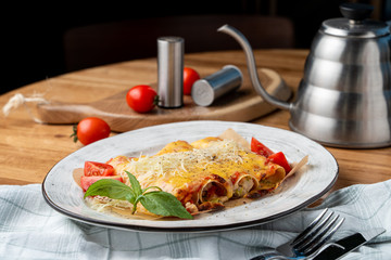 Cannelloni stuffed with turkey and vegetables, with melted cheddar and mozzarella cheese