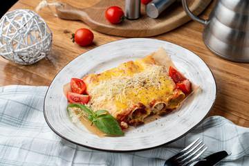 Cannelloni stuffed with turkey and vegetables, with melted cheddar and mozzarella cheese
