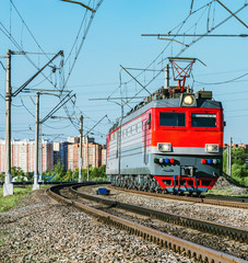 Freight train approaches to the station at evening time.