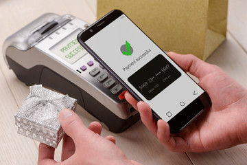 Man paying for jewelry gift with a mobile phone