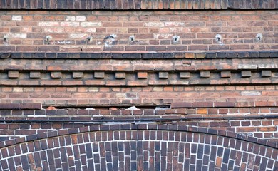 Old red brick facade of building - details of brick walls, cornice © Iwona