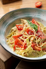 Italian spaghetti with chicken breast, creamy sauce and cheese close up
