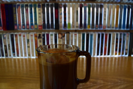 Close-Up Of Drink In Mug Against Bookshelf