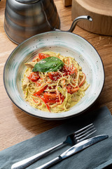 Italian pasta with chicken breast, creamy sauce and cheese on wooden table in an italian restaurant