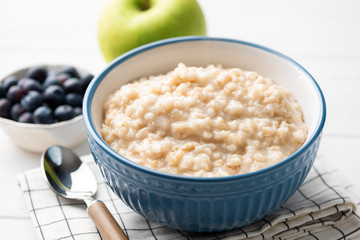 Healthy breakfast oatmeal porridge in bowl. Warm porridge oats, vegan vegetarian weight loss dieting breakfast food - 318369017