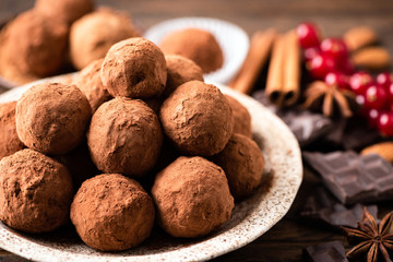 Homemade dark chocolate truffles on plate closeup view
