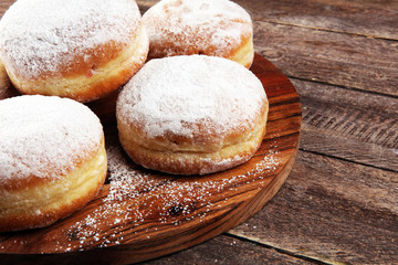 German donuts with jam and icing sugar. Carnival powdered sugar raised donuts for party