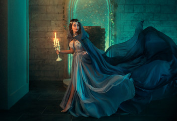 Luxury lady Queen medieval royal dress run escapes from Gothic night castle. Blue silk dress, cloak...