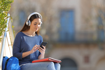 Student wearing headphones listening to music in a campus