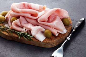 Sliced ham on wooden background. Fresh prosciutto. Pork ham sliced. pork meat cutting