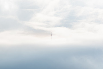 Obraz na płótnie Canvas cell tower in the mountains above the clouds lighthouse minimalist concept empty space text ad