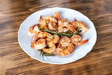 Fototapeta na wymiar Fried or Roasted tiger big shrimps in plate with spice, lime, rosemary and lemon. Grilled seafood. Healthy food. Prawns Scampi traditional dish. Appetizer langoustines.Top view. Space for text