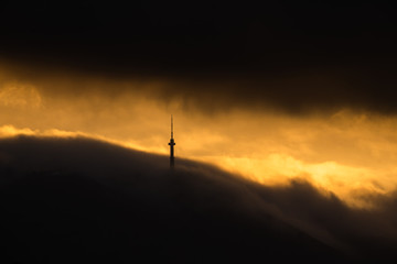 Communication tower in clouds golden sunset space for text natural beauty landscape gold smog mountain