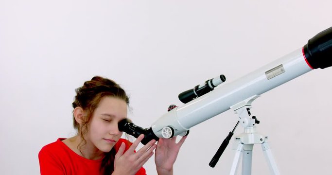 Girl posing with a telescope on a white isolated background