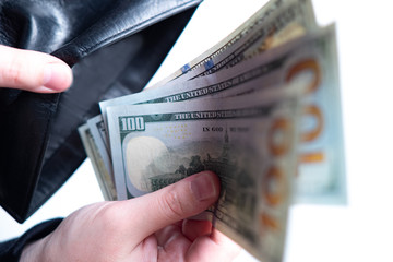 Finance. Man puts dollars in his wallet. Revenue. Savings. Investment. Capital. Competent budget management. Saving money from inflation. Payment mandatory payments.