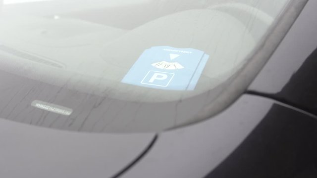 Mann legt Parkscheibe ins Auto 