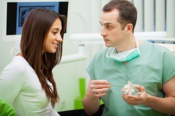 Dentist in dental office talking with female patient and preparing for treatment