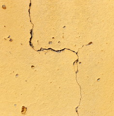 Cracked and Damaged Yellow Stucco Wall