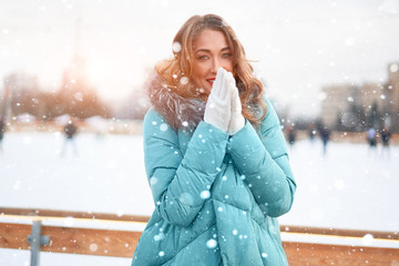 Beautiful lovely middle-aged girl with curly hair warm winter jackets stands ice rink background Town Square.