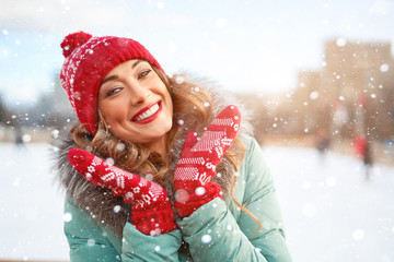 Beautiful lovely middle-aged girl with curly hair warm winter jackets stands ice rink background Town Square.