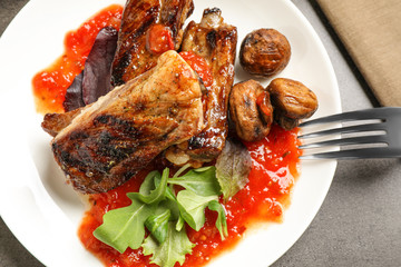 Delicious grilled ribs served on grey table, top view