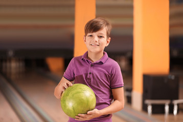 Fototapeta premium Preteen boy with ball in bowling club