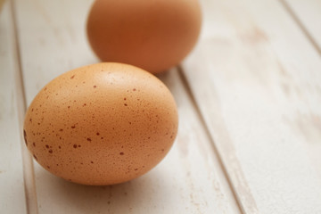 chicken eggs on white wooden shabby background close up