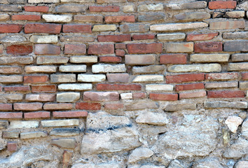 irregular white and red bricks  over rocks