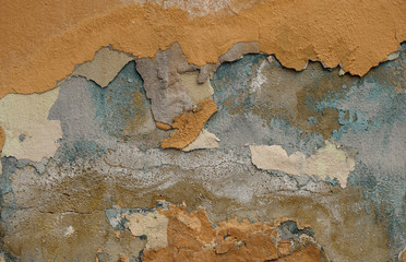 wall with several layers of peeling stucco