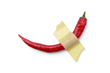 Red, hot pepper glued with yellow tape to a white surface. Modern pop-art.