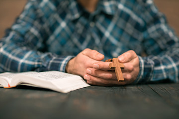 man hand wooden cross with Bible