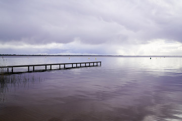 Fototapeta na wymiar wood access empty pontoon sunrise blue water winter on Lake Hourtin in Gironde france