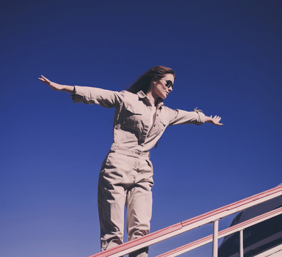 a beautiful stylish woman depicts a flight against a blue sky. casperia freedom