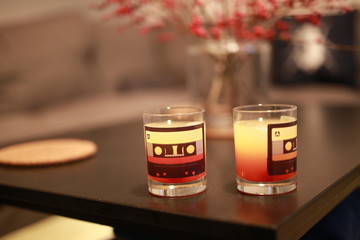 red yellow orange layered mixed alcohol drinks in cassette tape glasses on coffee table in living room