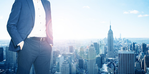 Businessman in suit standing near the window of New York downtown , USA