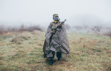 soldier with machine gun wearing chemical weapons protection suit