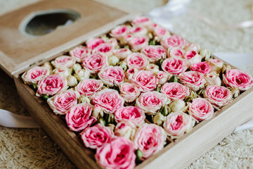 Wooden flower box arrangement with pink roses.
