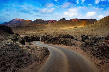 Image related to unexplored road journeys and adventures.Road through the scenic landscape to the destination in Timanfaya natural park in Lanzarote,Canary island,Spain