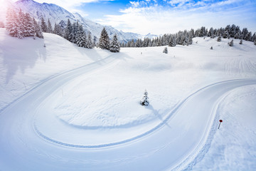Cross-country ski piste path in the mountains on good weather winter day.