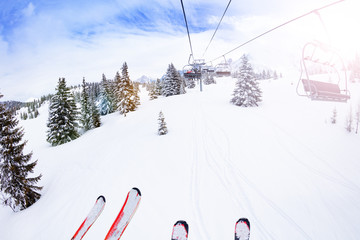Parts of ski and lift over magnificent snow covered fir forest view on Alpine mountain resort