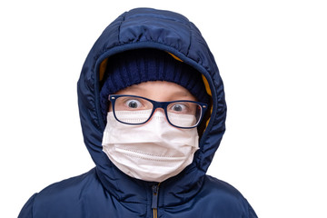 Concept of coronavirus quarantine. A boy in winter clothes and a white respiratory medical surgical mask as a protection from viruses and bacteria