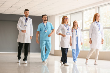 Team of doctors going along hall in clinic