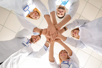 Team of doctors putting hands together, bottom view