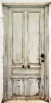 Old worn white door damaged and with ancient texture from an abandoned building