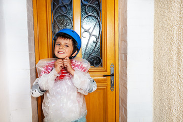 Boy fasten helmet wear super safe bubble wrap have overprotective mother standing near home door