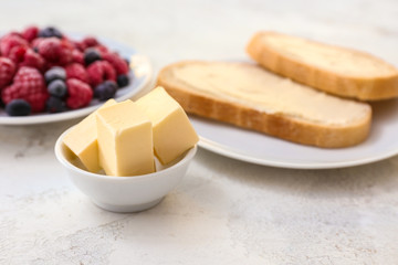 Fresh butter with slices of bread and berries on white background