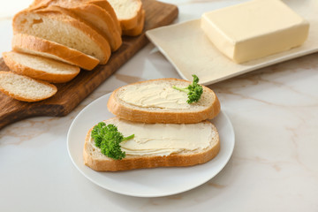 Plate with slices of bread and fresh butter on white background