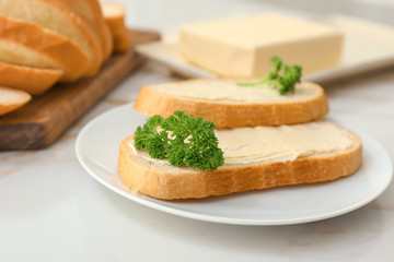 Plate with slices of bread and fresh butter on white background