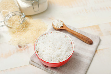 Boiled rice in bowl on white wooden table